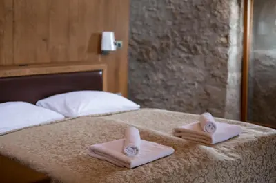 a bed with two folded towels on top of it at Vinica Castle Boutique & Spa Hotel in Vinica