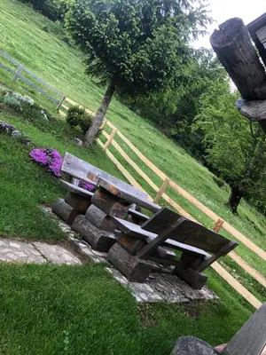 a picnic table and bench in a park at Mountain Lodge Suška Koča in Stahovica