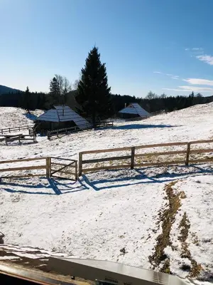 a snow covered field with a fence and tents at Mountain Lodge Suška Koča in Stahovica