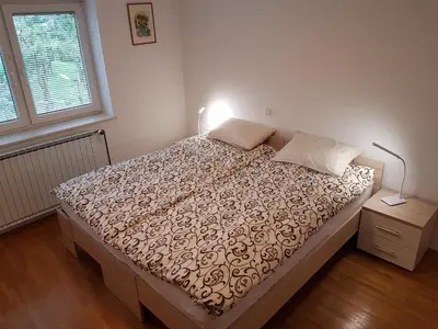 a bedroom with a bed and a lamp and a window at Apartment Venko in Slovenske Konjice