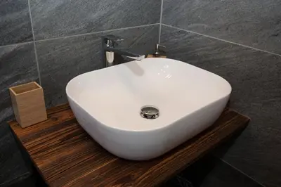 a white sink sitting on a wooden platform in a bathroom at Family fun Pohorje in Ruše