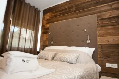a bedroom with a bed with white sheets and pillows at Family fun Pohorje in Ruše