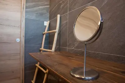 a mirror sitting on top of a wooden table at Family fun Pohorje in Ruše