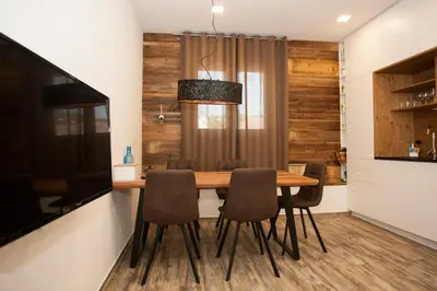 a dining room with a wooden table and chairs at Family fun Pohorje in Ruše