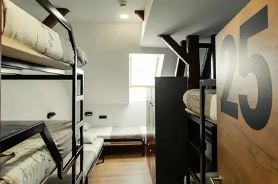 a room with two bunk beds and a window at Hostel Vila Pohorje in Slovenj Gradec