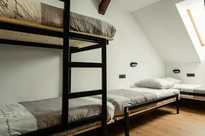 two bunk beds in a room with white walls at Hostel Vila Pohorje in Slovenj Gradec