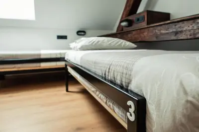 a bedroom with a large bed with a wooden headboard at Hostel Vila Pohorje in Slovenj Gradec