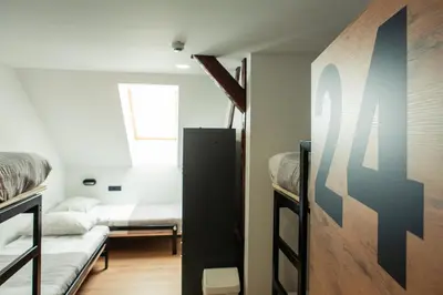 a room with two bunk beds and a window at Hostel Vila Pohorje in Slovenj Gradec