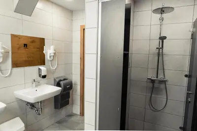 a bathroom with a shower and a sink at Hostel Vila Pohorje in Slovenj Gradec