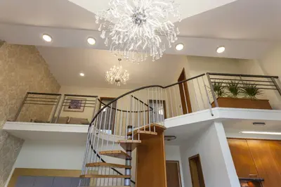 a staircase in a house with a chandelier at Duplex Penthouse Aparthotel Rosa in Podčetrtek