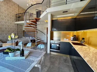 a kitchen with black cabinets and a spiral staircase at Duplex Penthouse Aparthotel Rosa in Podčetrtek