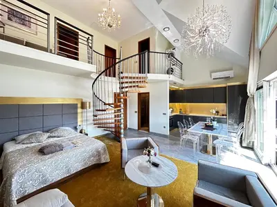 a bedroom with a bed and a spiral staircase at Duplex Penthouse Aparthotel Rosa in Podčetrtek