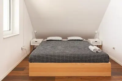 a bedroom with a black and white bed with two night stands at Hillhouse Novo mesto in Novo Mesto