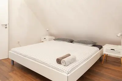 a white bed with two pillows on top of it at Hillhouse Novo mesto in Novo Mesto
