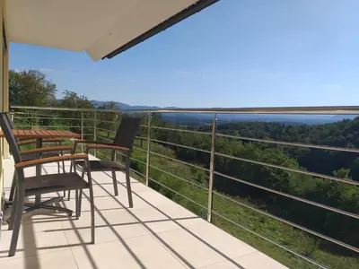 a balcony with two chairs and a table with a view at Hillhouse Novo mesto in Novo Mesto
