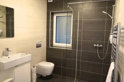 a bathroom with a toilet and a sink and a shower at Hillhouse Novo mesto in Novo Mesto