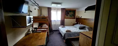 a small room with a bed and a television at Planinski Dom na Travni Gori in Sodražica