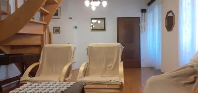 a living room with three chairs and a staircase at Lovely Old City-Center Apartment in Ljubljana