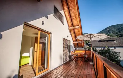 a balcony with a table and an umbrella at Apartments Izvir in Bohinj
