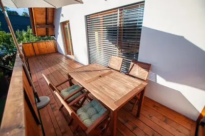 a wooden table and chairs on a deck at Apartments Izvir in Bohinj