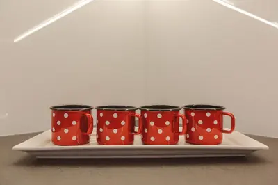 four red and white polka dot mugs on a tray at Apartments and Rooms Kaja in Kranjska Gora