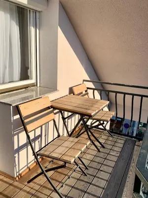 a wooden table and two chairs on a balcony at Hotel Maj Inn in Moravske Toplice