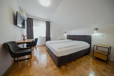 a bedroom with a large bed and a table and chairs at Hotel Maj Inn in Moravske Toplice