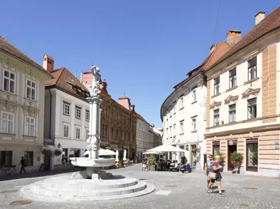 a street with a fountain in the middle of a city at City Pearl Apartment in Ljubljana