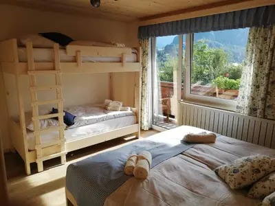 a bedroom with two bunk beds and a window at Apartmaji Pavc in Bohinj