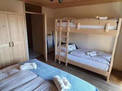 a bedroom with two bunk beds and a ladder at Apartmaji Pavc in Bohinj