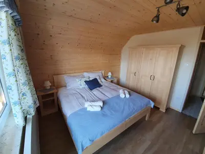 a bedroom with a bed in a wooden room at Apartmaji Pavc in Bohinj