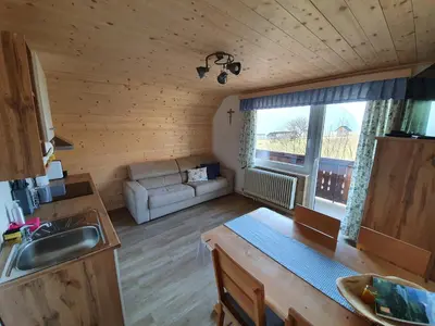 a kitchen and living room in a log cabin at Apartmaji Pavc in Bohinj