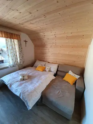 a bed and a couch in a room at Apartmaji Pavc in Bohinj