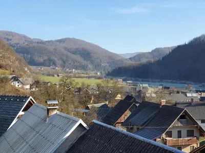 a group of roofs of houses with mountains in the background at Apartmaji Pavc in Bohinj