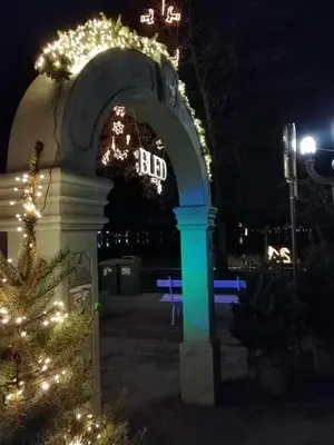 an arch with christmas lights in a park at night at APARTMA CARNICA in Bled