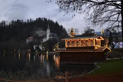 a building in the middle of a lake at night at APARTMA CARNICA in Bled