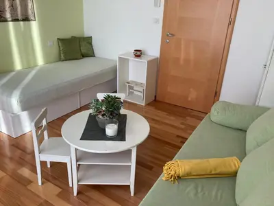 a small living room with a table and a couch at Natasha's Garden House in Dol pri Ljubljani