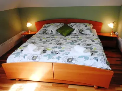 a bed in a bedroom with two lamps on tables at Natasha's Garden House in Dol pri Ljubljani