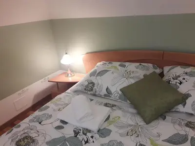 a bed with a pillow and a table with a lamp at Natasha's Garden House in Dol pri Ljubljani
