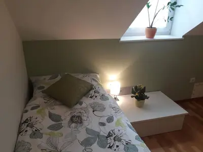 a bedroom with a bed with a pillow and a window at Natasha's Garden House in Dol pri Ljubljani