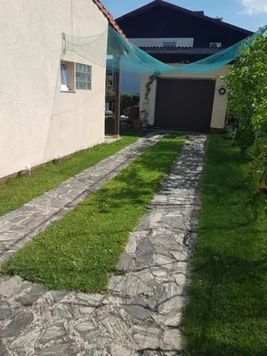 a stone walkway leading to a house with a tent at Charming house 