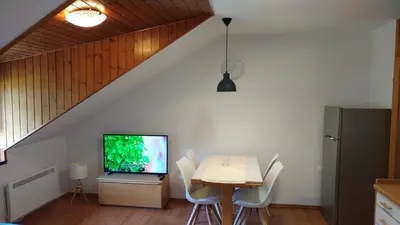 a dining room with a table and a tv at Ajda apartment in Kranjska Gora