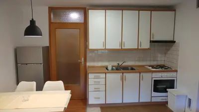 a kitchen with white cabinets and a sink at Ajda apartment in Kranjska Gora