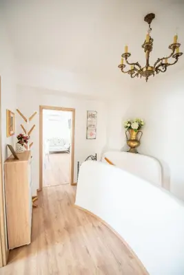 a white room with a bed and a chandelier at Apartmaji Urška in Laško