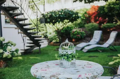 a bird cage sitting on a table in a yard at Apartmaji Urška in Laško