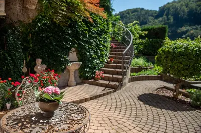 a patio with a table with a vase of flowers at Apartmaji Urška in Laško