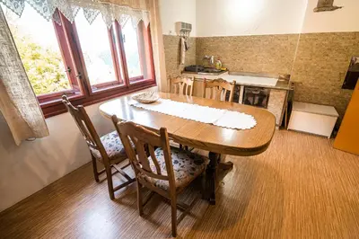 a kitchen with a wooden table and chairs in a room at Country House Sara in Rečica ob Savinji
