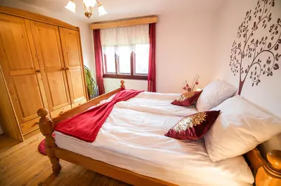 a bedroom with a bed with red and white pillows at Country House Sara in Rečica ob Savinji