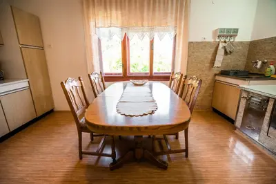 a dining room table with chairs and a kitchen at Country House Sara in Rečica ob Savinji