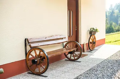 a wooden bench sitting next to a door at Country House Sara in Rečica ob Savinji